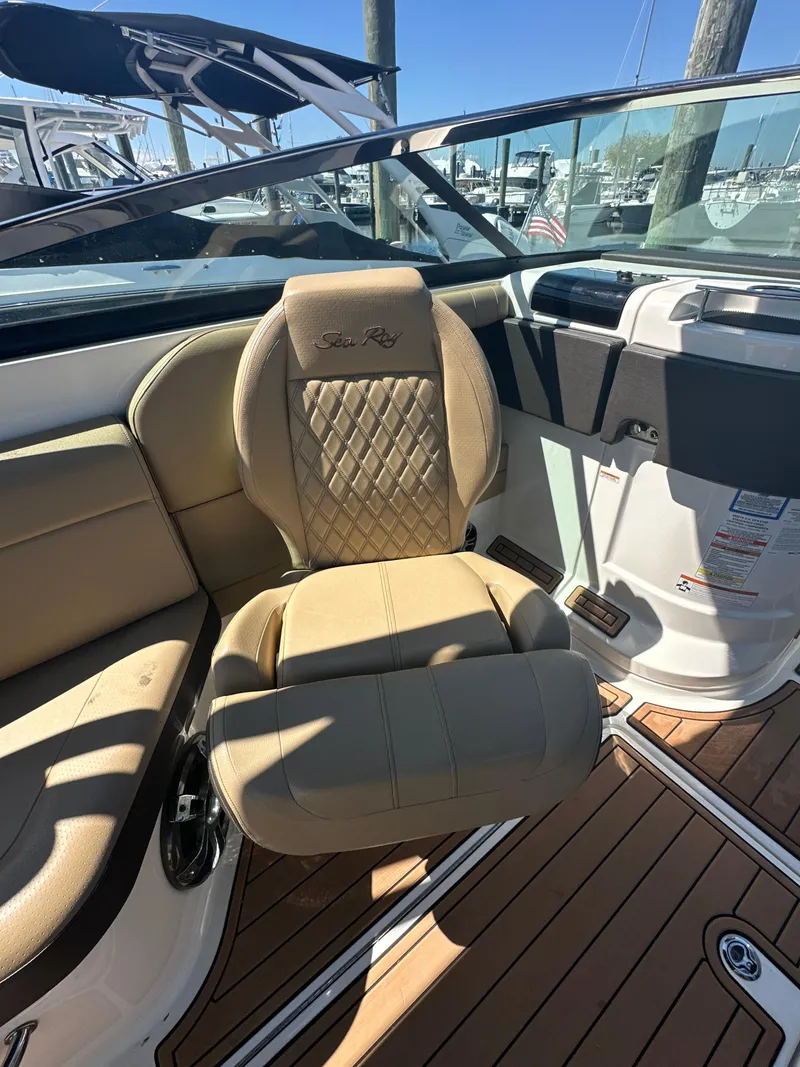 Slide: The Image of 2019 Sea Ray SLX 280 boat interior with tan seating and wood flooring. - 27