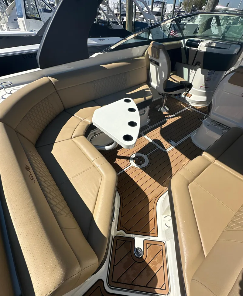 Slide: The Image of 2019 Sea Ray SLX 280 boat interior with tan seating and wooden flooring. - 35