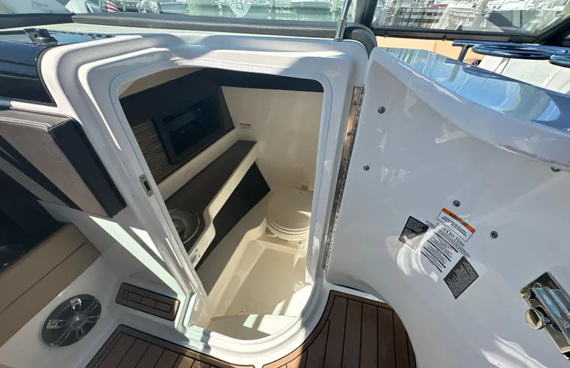 Slide: The Image of 2019 Sea Ray SLX 280 boat interior with open cabin door, showcasing compact amenities. - 43