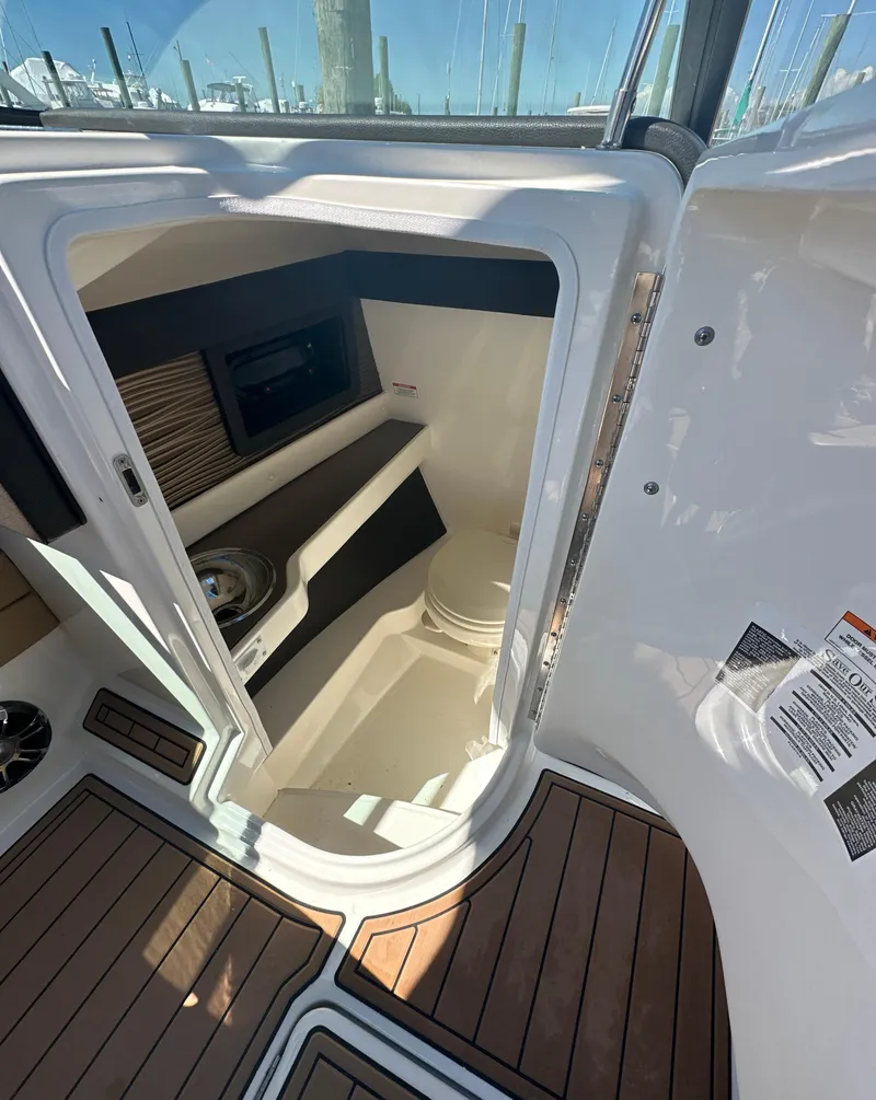 Slide: The Image of 2019 Sea Ray SLX 280 boat interior with wood flooring and compact cabin space. - 45