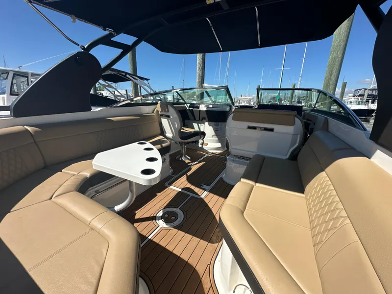 Slide: The Image of 2019 Sea Ray SLX 280 boat interior with tan seating and a white table. - 6