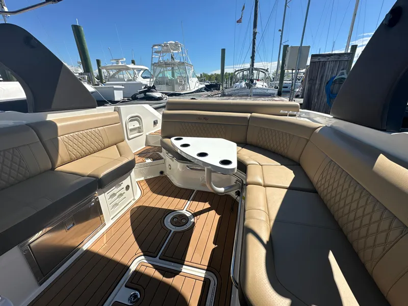 Slide: The Image of 2019 Sea Ray SLX 280 boat interior with tan seating and wooden deck. - 8