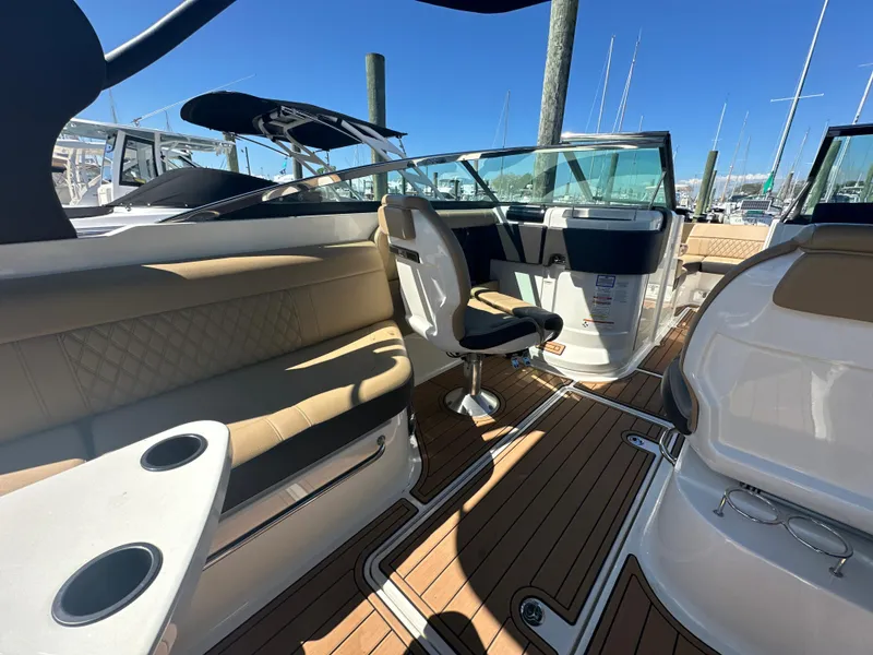 Slide: The Image of 2019 Sea Ray SLX 280 boat interior with tan seating and wooden flooring. - 9