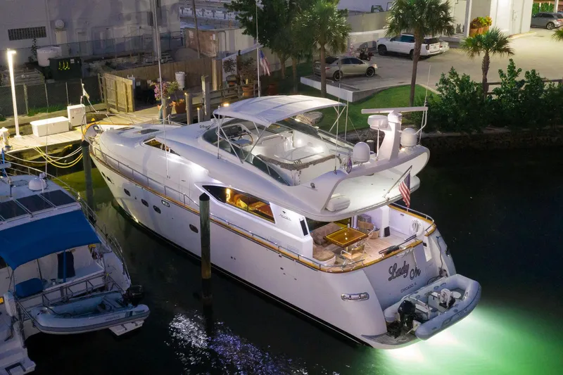 Slide: The Image of Luxurious 1997 Maiora FIPA 70' Flybridge yacht docked at night, illuminated by underwater lights. - 1