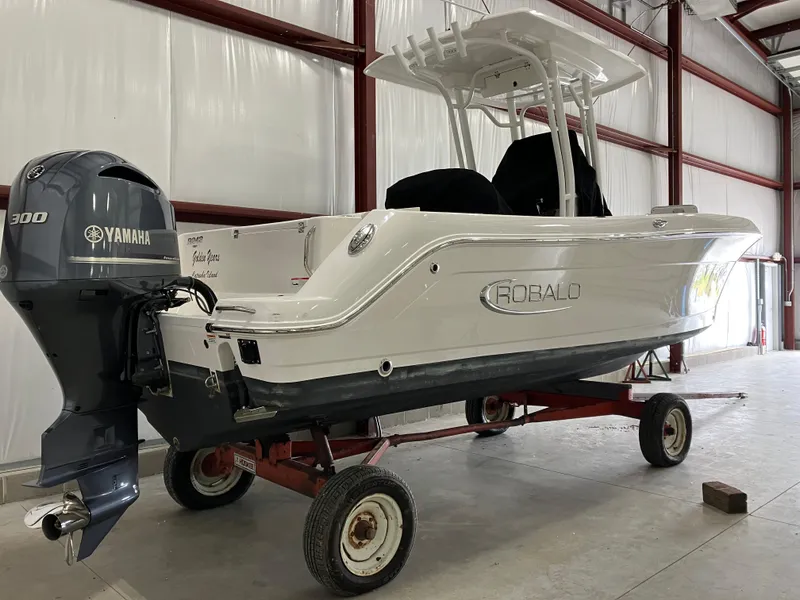 Slide: The Image of 2021 Robalo R242 Center Console boat with Yamaha 300 engine in a storage facility. - 2
