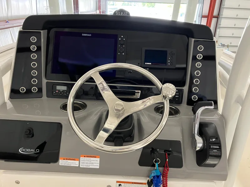 Slide: The Image of 2021 Robalo R242 Center Console dashboard with steering wheel and navigation controls. - 23