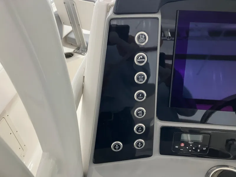 Slide: The Image of Control panel of 2021 Robalo R242 Center Console boat with buttons and display screen. - 29