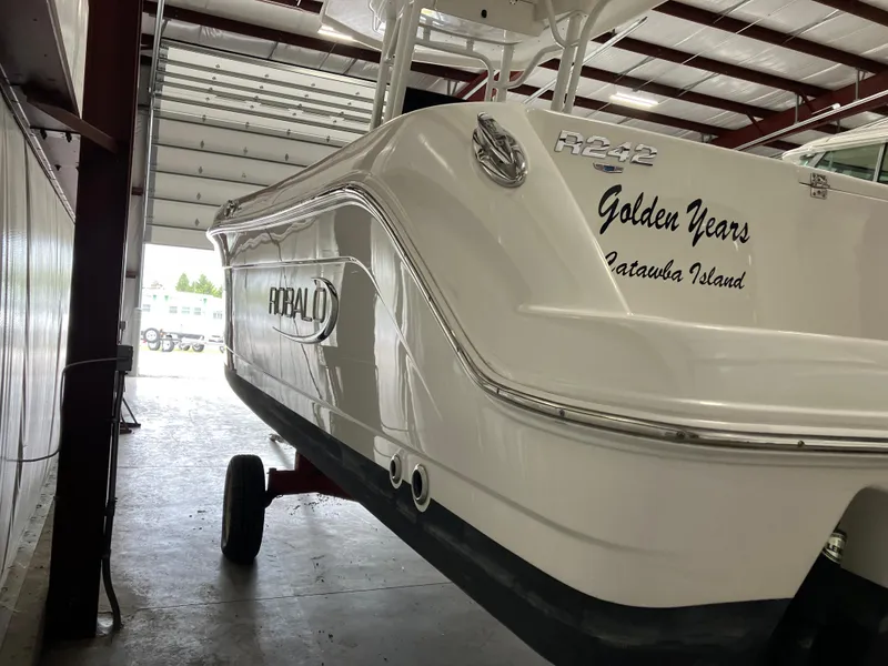 Slide: The Image of 2021 Robalo R242 Center Console boat in storage, featuring "Golden Years" on the hull. - 3