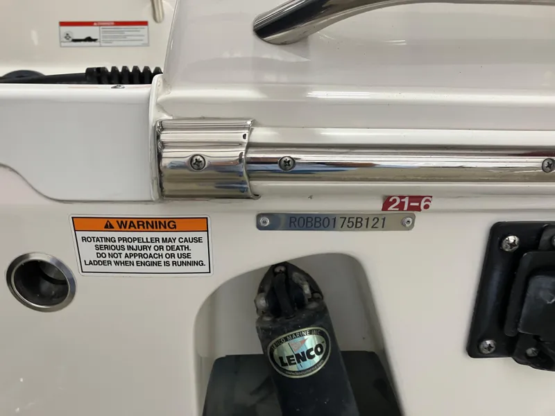 Slide: The Image of 2021 Robalo R242 Center Console boat detail with warning label and Lenco trim tab. - 35