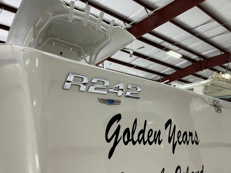 Slide: The Image of 2021 Robalo R242 Center Console boat with "Golden Years" text in a warehouse setting. - 36