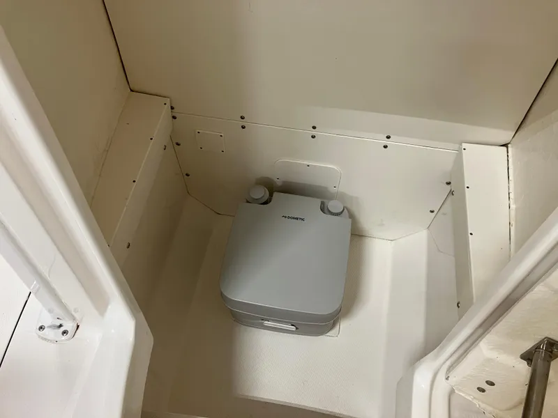 Slide: The Image of 2021 Robalo R242 Center Console boat interior with portable toilet. - 40