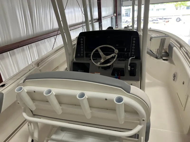 Slide: The Image of 2021 Robalo R242 Center Console boat interior with steering wheel and rod holders. - 45