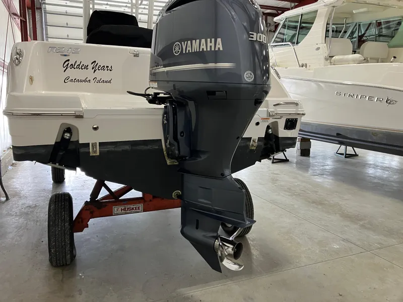 Slide: The Image of 2021 Robalo R242 Center Console with Yamaha 300 engine in a boat storage facility. - 8