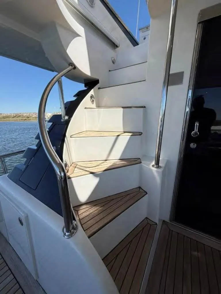 Slide: The Image of Staircase on 2000 Horizon E 65 yacht with wooden steps and metal railing. - 13