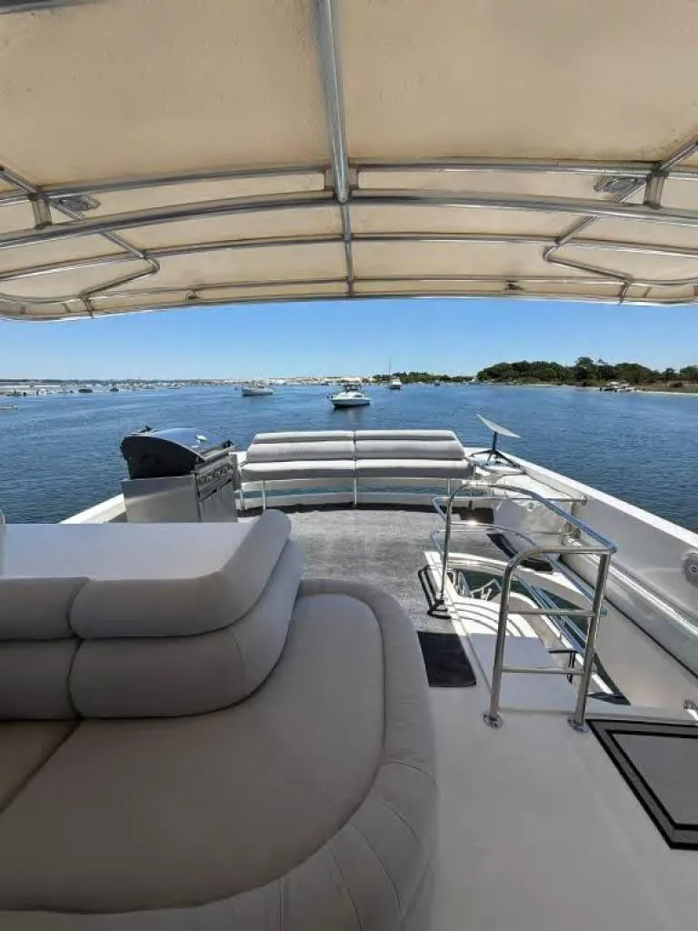 Slide: The Image of Luxury Horizon E 65 yacht deck with seating, canopy, and scenic water view. - 20