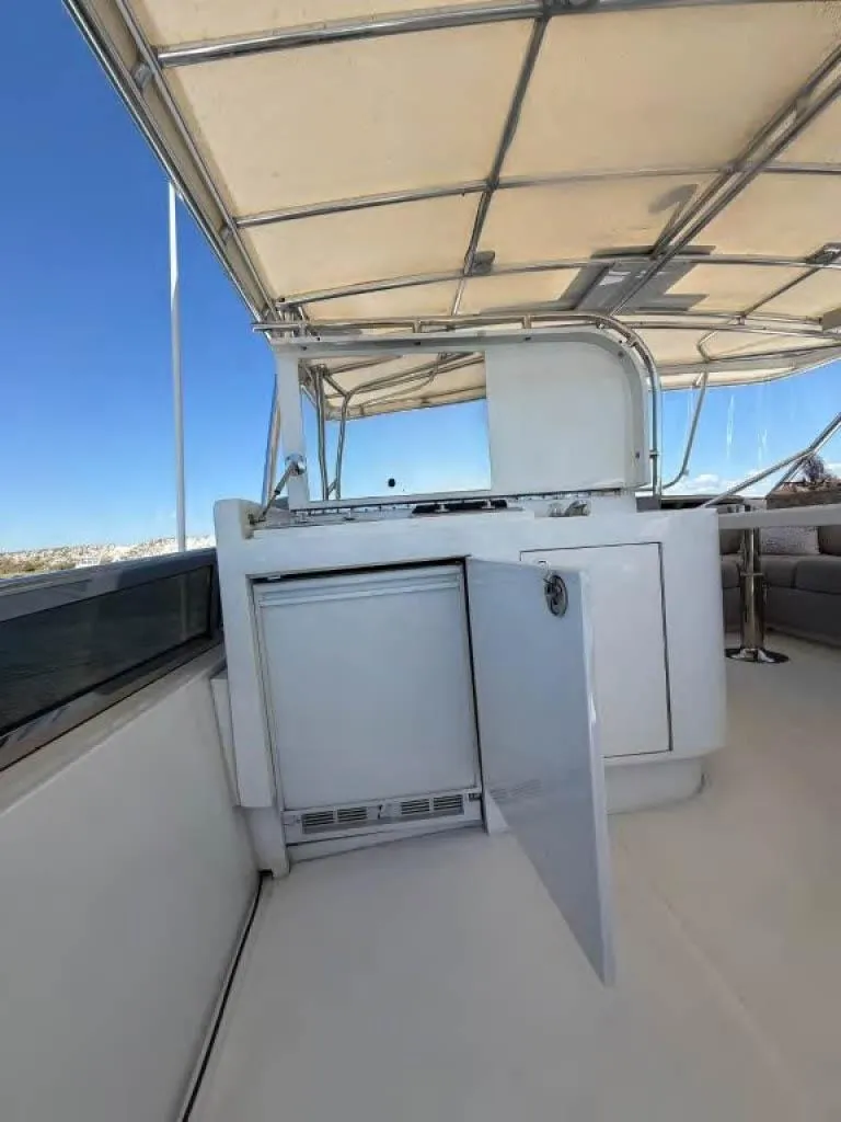 Slide: The Image of Luxury yacht Horizon E 65, 2000 model, featuring a sleek outdoor kitchenette. - 22