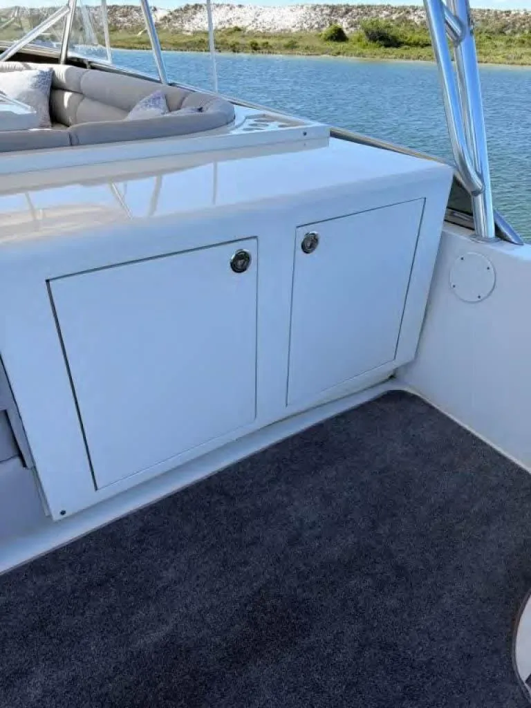 Slide: The Image of Horizon E 65 boat interior with storage cabinet, carpeted floor, and scenic water view. - 23