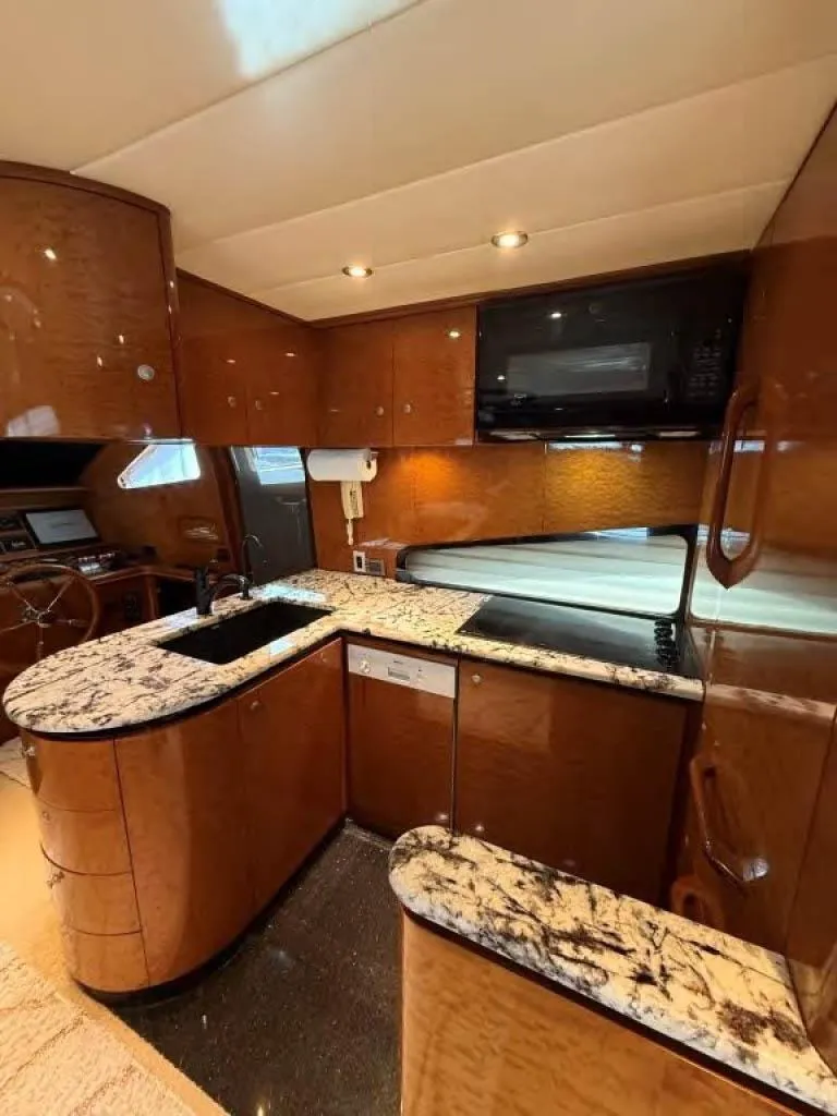 Slide: The Image of Luxurious kitchen in 2000 Horizon E 65 yacht with marble countertops and wood cabinetry. - 31