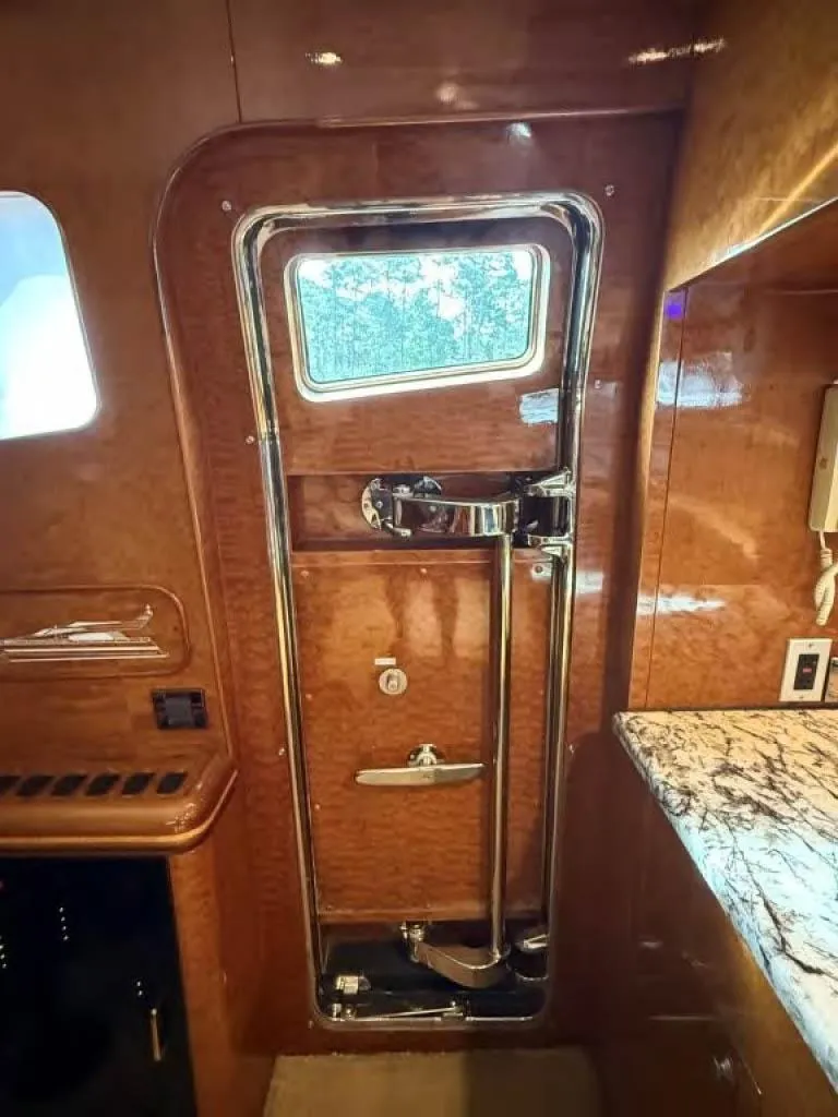 Slide: The Image of Luxurious wooden interior of 2000 Horizon E 65 yacht with window and marble countertop. - 32