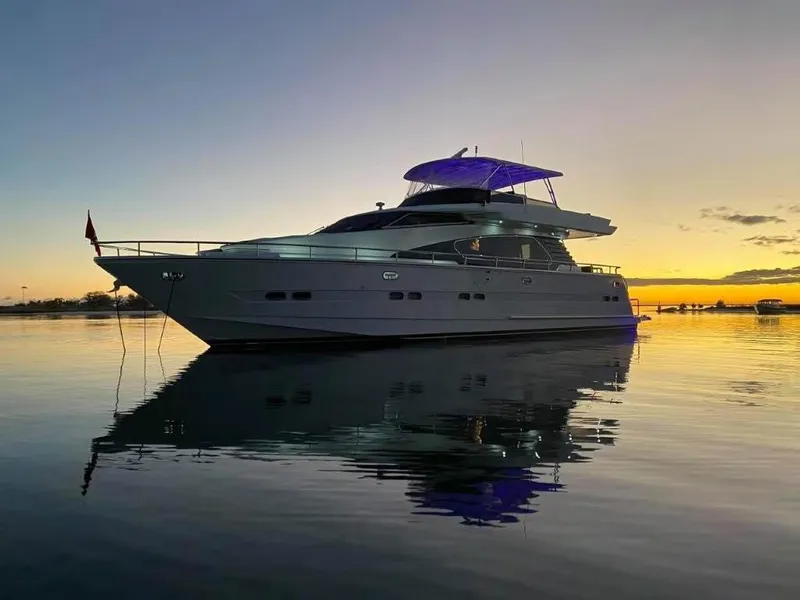 Slide: The Image of Luxury Horizon E 65 yacht at sunset, reflecting on calm water, 2000 model. - 4