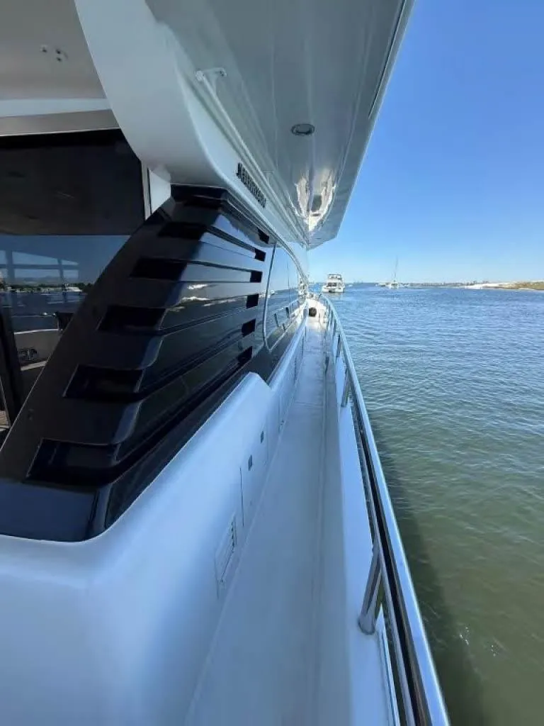 Slide: The Image of Side view of 2000 Horizon E 65 yacht on calm water under clear blue sky. - 6