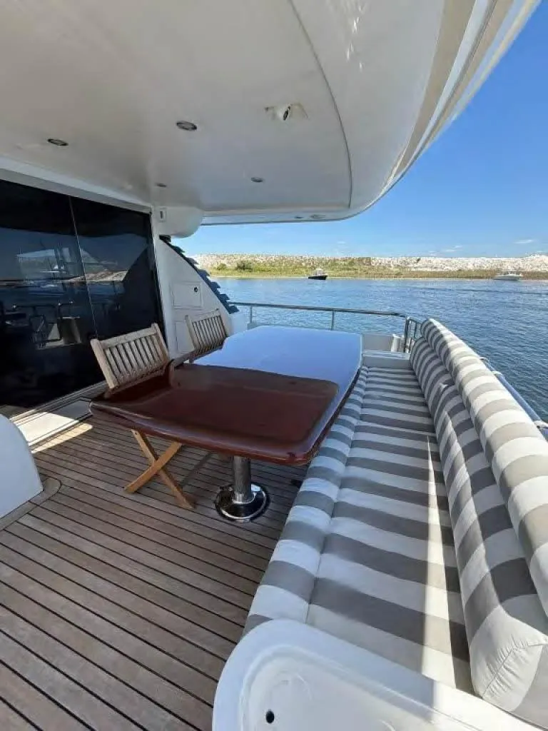 Slide: The Image of Luxury Horizon E 65 yacht deck with seating, table, and scenic water view, 2000 model. - 8