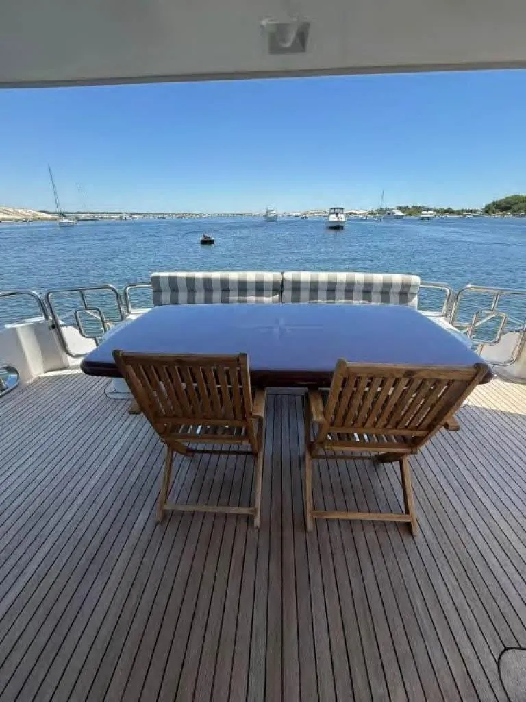 Slide: The Image of Luxury yacht deck with wooden chairs, table, and ocean view; Horizon E 65, 2000 model. - 9