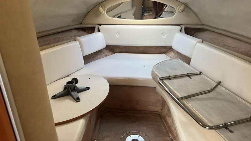 Slide: The Image of 2000 Regal Commodore 2460 cabin interior with white seating and table. - 10