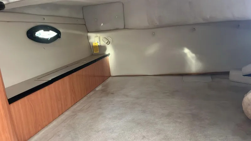 Slide: The Image of Interior cabin of 2000 Regal Commodore 2460 boat, featuring wood accents and carpeted flooring. - 11