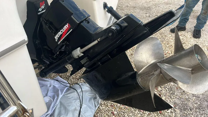 Slide: The Image of 2000 Regal Commodore 2460 boat with Mercury outboard motor and propeller on gravel surface. - 13