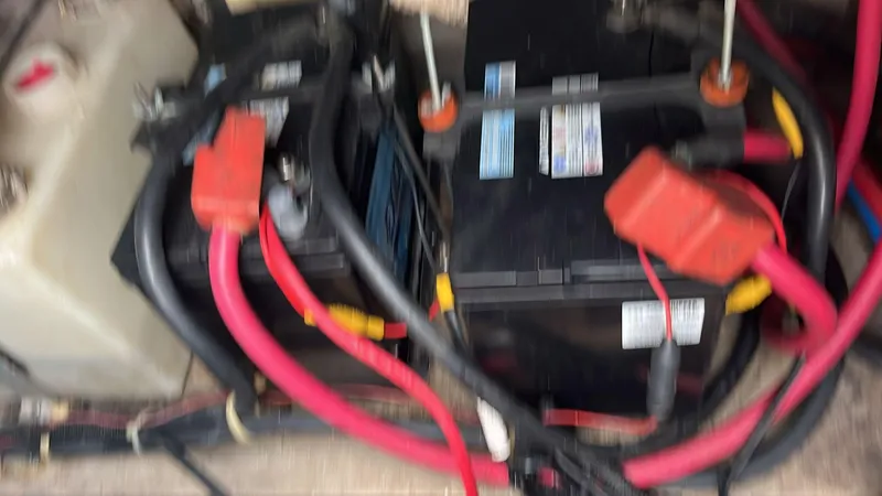Slide: The Image of Battery compartment of a 2000 Regal Commodore 2460 with red and black cables. - 14