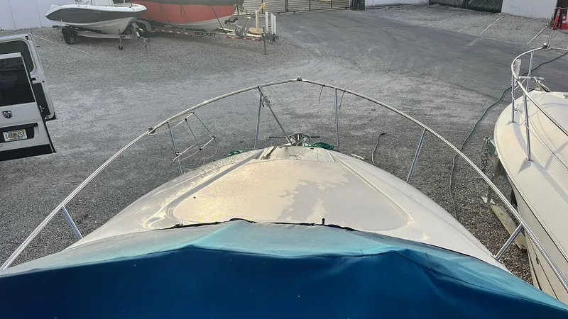 Slide: The Image of 2000 Regal Commodore 2460 boat docked in a gravel lot, viewed from the bow. - 3