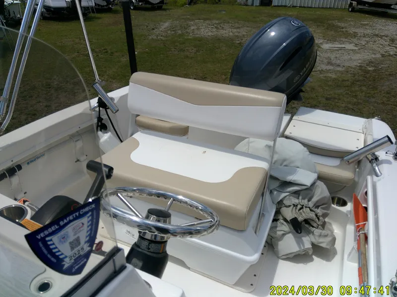 Slide: The Image of 2018 Robalo R160 cc boat interior with steering wheel and seating. - 11