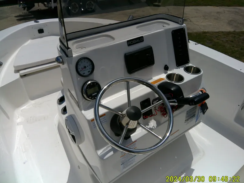 Slide: The Image of 2018 Robalo R160 cc boat console with steering wheel and gauges. - 13