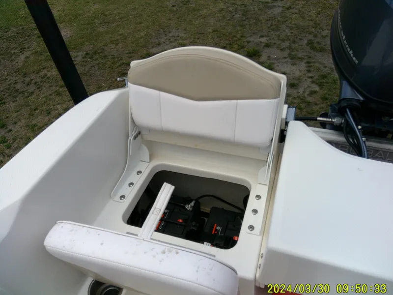Slide: The Image of 2018 Robalo R160 cc boat seat with storage compartment open, revealing battery inside. - 16
