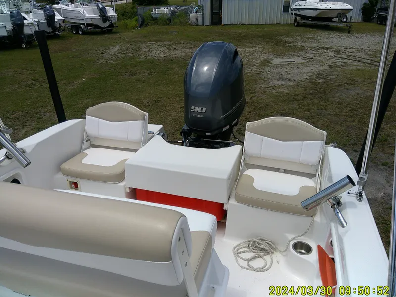 Slide: The Image of 2018 Robalo R160 cc boat with Yamaha 90 engine, beige seating, and outdoor setting. - 17