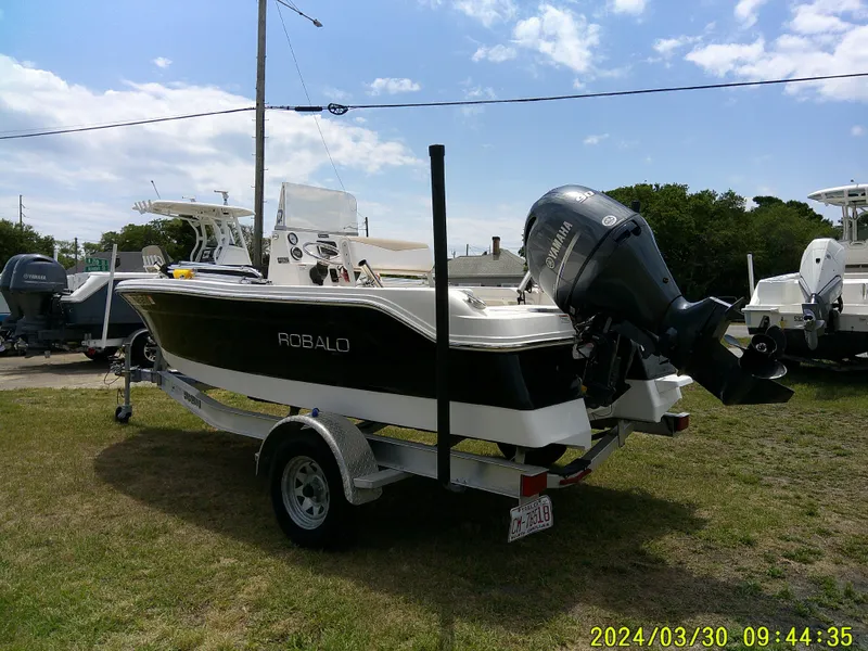 Slide: The Image of 2018 Robalo R160 cc boat on trailer, parked outdoors under a clear sky. - 4