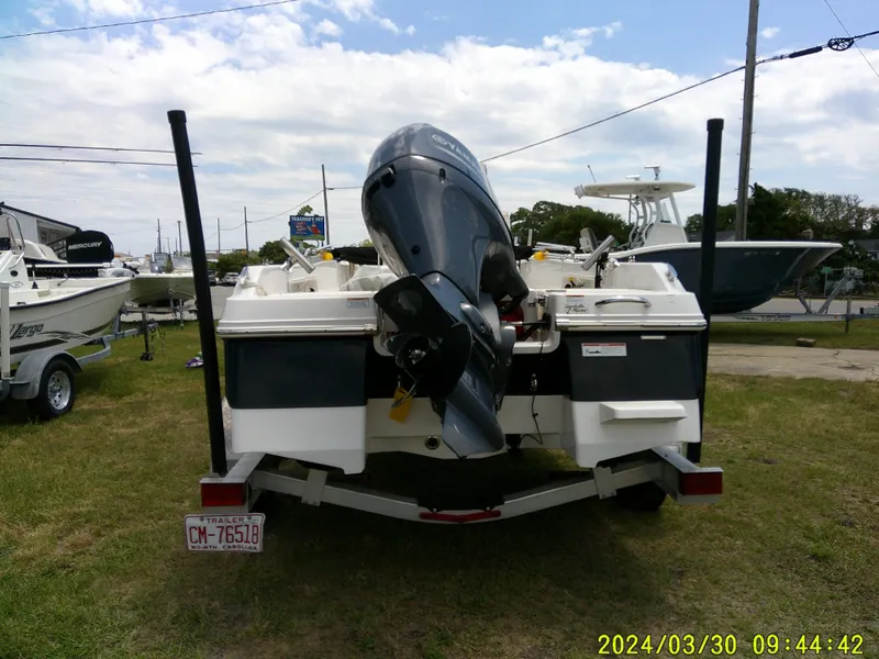 Slide: The Image of 2018 Robalo R160 cc boat on trailer, rear view with outboard motor, parked outdoors. - 5