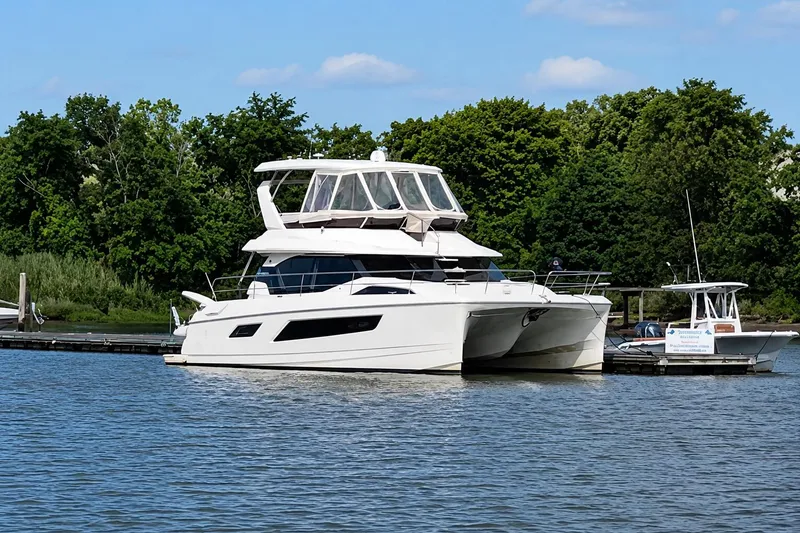 Slide: The Image of Aquila 44 Yacht 2016 docked on a serene lake with lush green trees. - 16