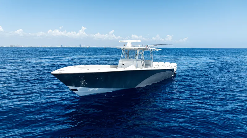 Slide: The Image of 2019 SeaVee 390Z boat on open ocean, clear sky, distant city skyline. - 2