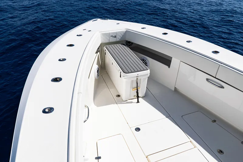 Slide: The Image of 2019 SeaVee 390Z boat deck with seating and storage, on calm blue ocean. - 20