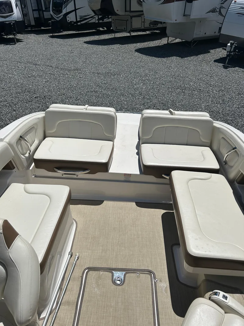 Slide: The Image of 2016 Chaparral 257 SSX boat interior with beige seating and carpeted floor. - 11