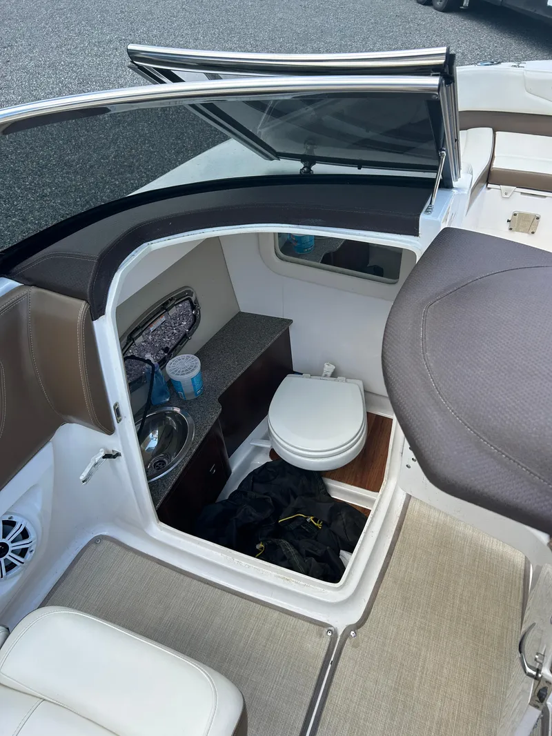Slide: The Image of 2016 Chaparral 257 SSX boat interior with compact bathroom and sink. - 16