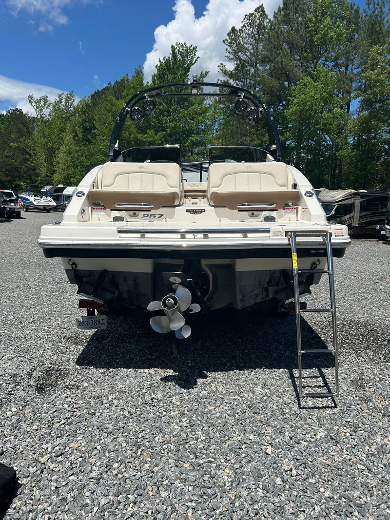 Slide: The Image of 2016 Chaparral 257 SSX boat, rear view, on gravel lot with trees in background. - 3