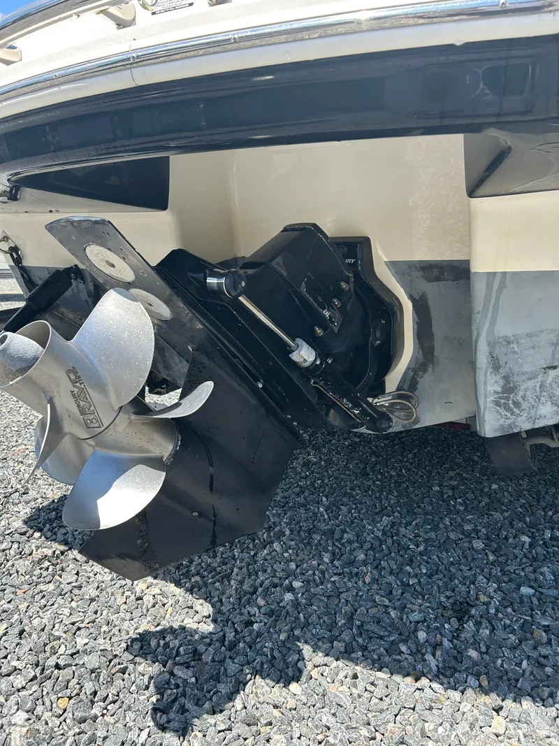 Slide: The Image of 2016 Chaparral 257 SSX boat stern with propeller and outdrive on gravel surface. - 4
