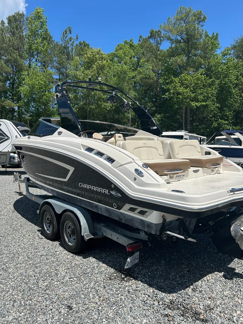 Slide: The Image of 2016 Chaparral 257 SSX boat on trailer, parked outdoors with trees in background. - 6