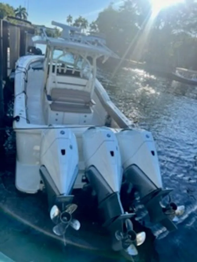 Slide: The Image of 2017 Scout LXF 350 boat with triple outboard engines docked in sunny waters. - 6