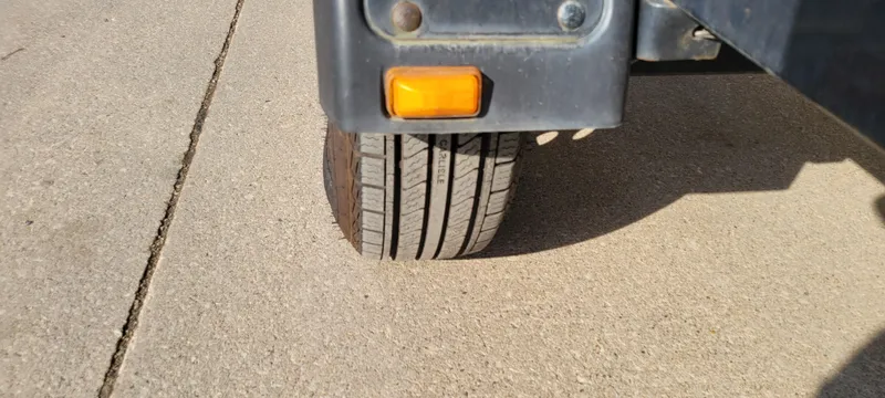 Slide: The Image of Trailer wheel and light of a 2004 Sylvan F 1800 AVENGER on concrete. - 14