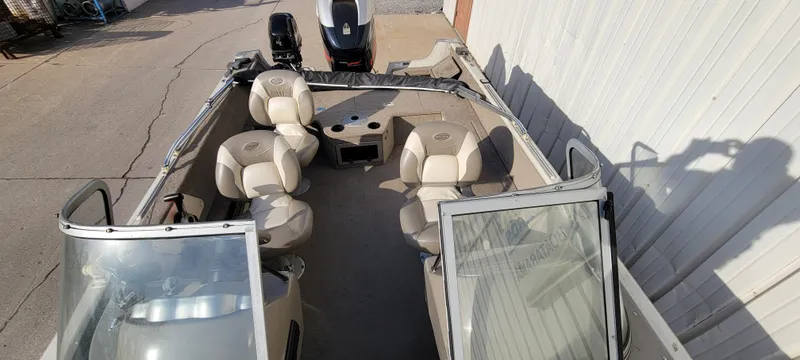 Slide: The Image of 2004 Sylvan F 1800 Avenger boat with seating and windshield, parked outdoors. - 18