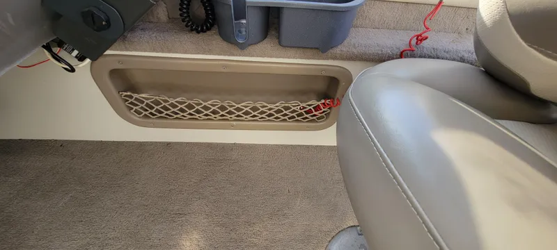 Slide: The Image of Interior of a 2004 Sylvan F 1800 Avenger boat, featuring seating and storage compartment. - 19